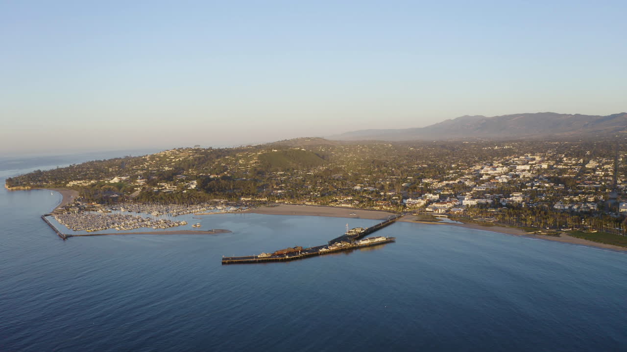 ángulo de drones de santa barbara california mirando hacia la ciudad portuaria con olas del océano y barcos 4k prores