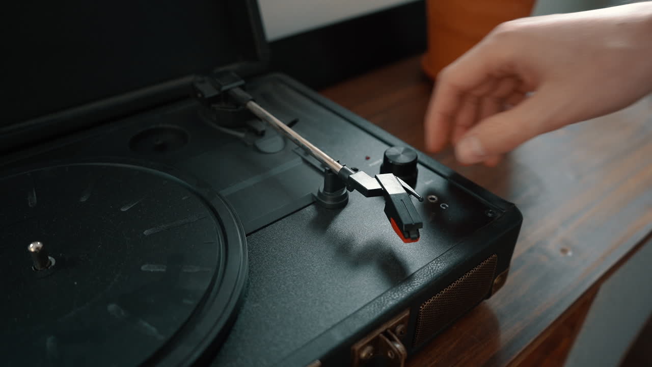A hand turns on a turntable.