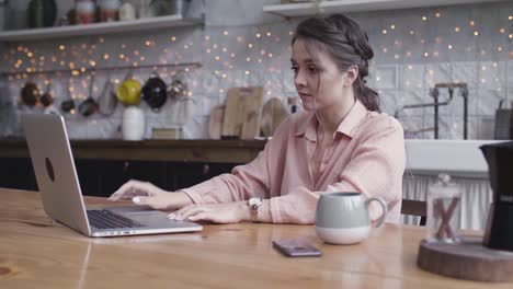 woman working on laptop in a kitchen