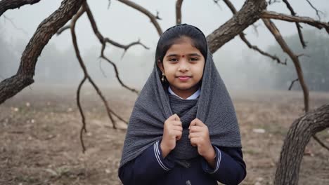 smiling young student wearing a cozy gray scarf, enjoying a cold and foggy morning in a park surrounded by bare trees, exuding warmth and innocence in the tranquil winter landscape