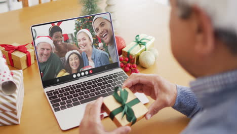 animation of biracial man in santa hat on laptop video call with family at christmas