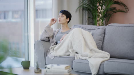 a young woman using a smartphone on the sofa