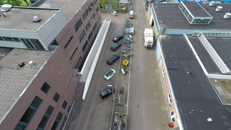 Drone-flying-over-parked-cars-in-industrial-area