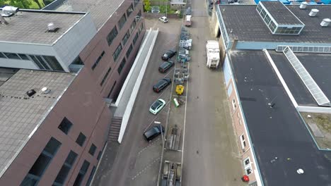 drone flying over parked cars in industrial area