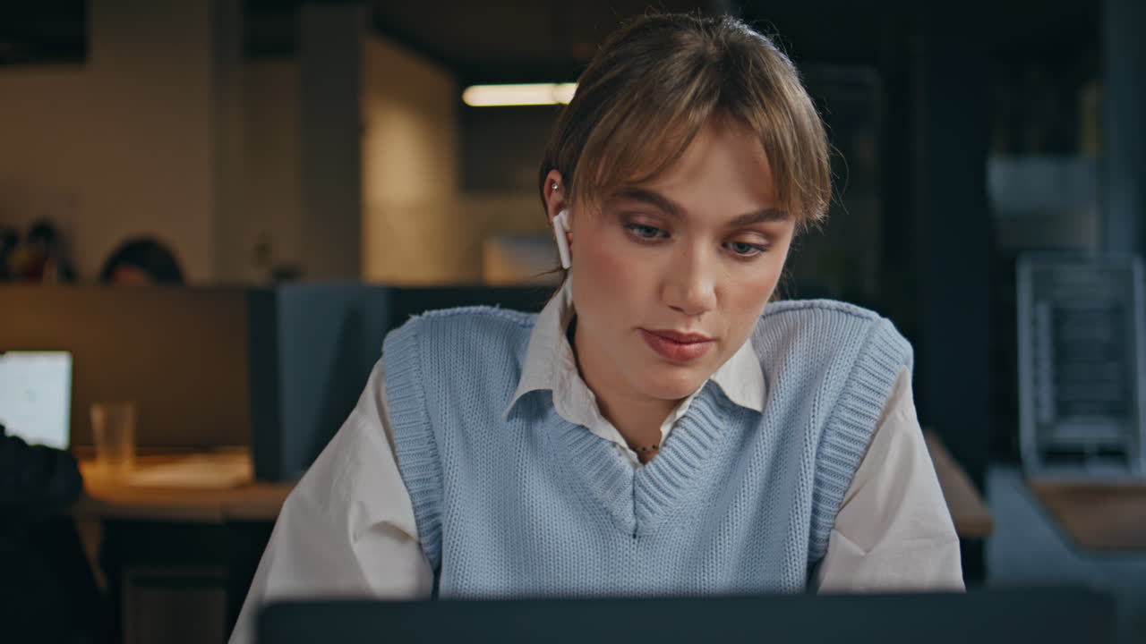 Office lady inserting earphones at computer workplace closeup. Woman video call