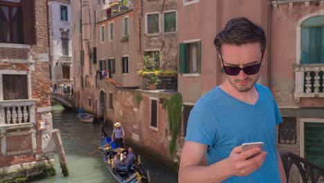 hombre mirando su teléfono en venecia
