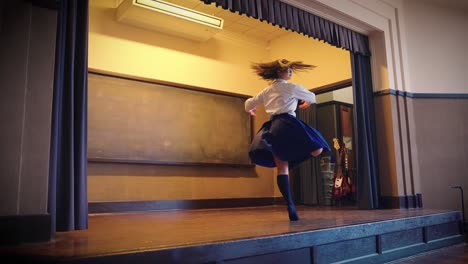 japanese high school girl in uniform does ballet on school stage