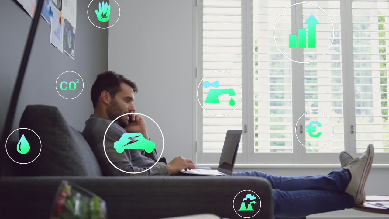 Animation of green energy concept icons against caucasian man taking on smartphone at office