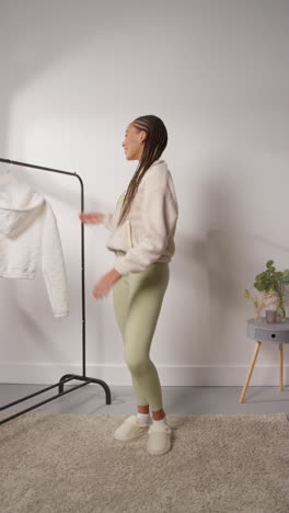 vertical pov video of female social media influencer producing user generated content in studio modelling a variety of fashion outfits shot in real time 7