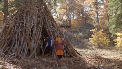 cuatro niños pequeños jugando juntos en un bosque