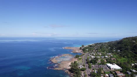 Drone-footage-following-the-highway-along-the-North-coast-of-the-island-of-Oahu-in-the-Hawaiian-islands-with-blue-ocean-water-and-tide-pools-along-the-shore