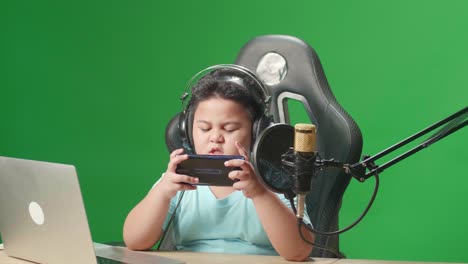 camera and asian little boy playing video game with mobile phone then lose the game while live stream on green screen