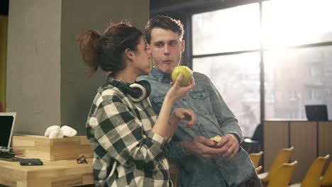 pareja de dos jóvenes felices divirtiéndose juntos, comiendo manzanas y disfrutando de sus vidas. trajes urbanos hipster. juventud, generación milenaria.