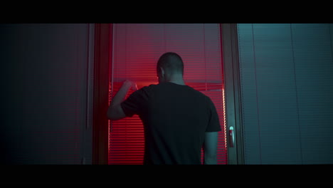 man looking out of a window at night
