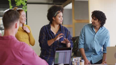 Happy-diverse-business-people-discussing-work-during-meeting-at-office