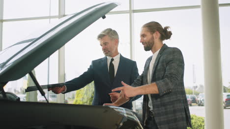 vendedor de coches discutiendo el coche con el cliente
