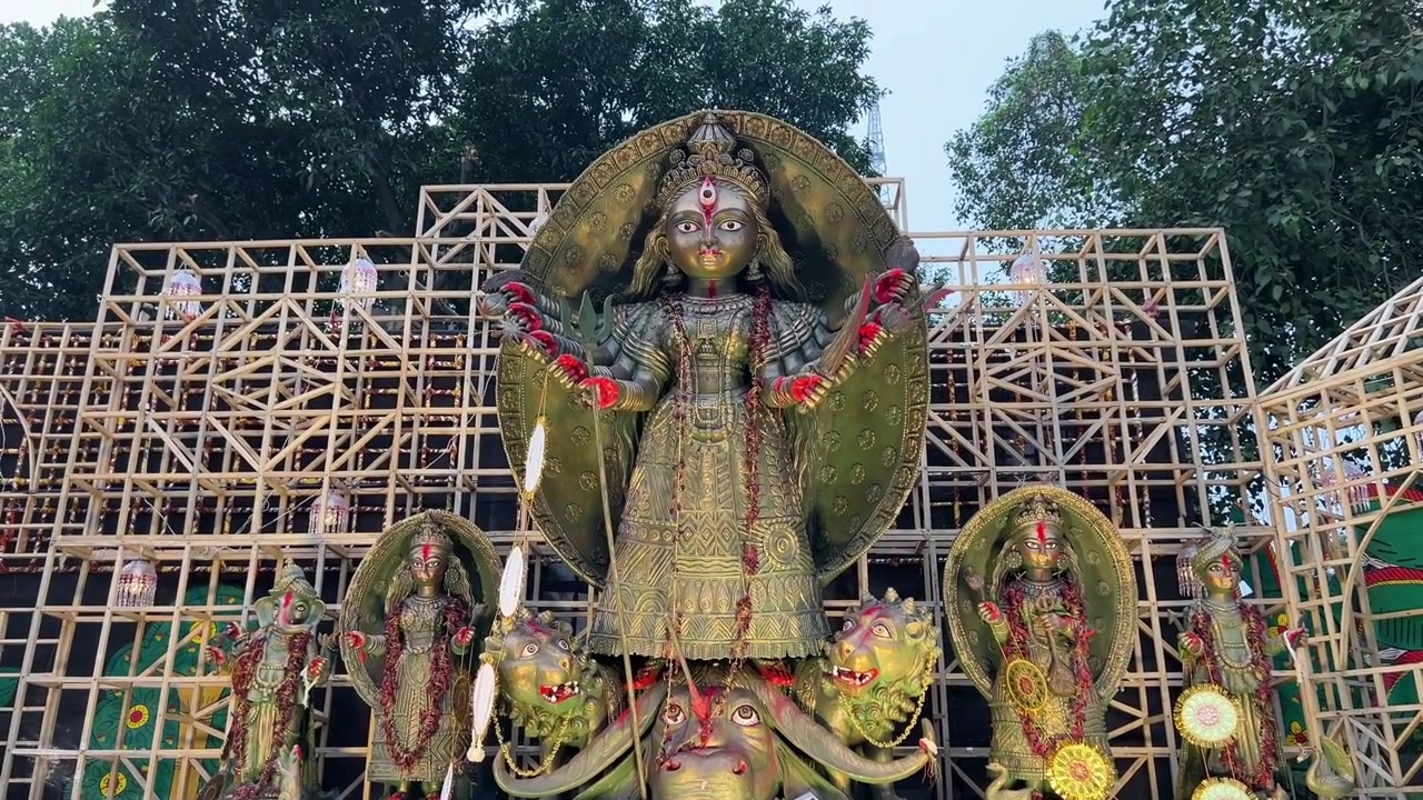 Ídolo de Maa Durga com aparência metálica ao entardecer em procissão na Red Road de Calcutá, Índia.