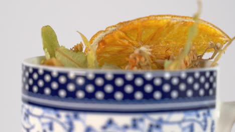 linden flower and dried orange in mug herbal remedy