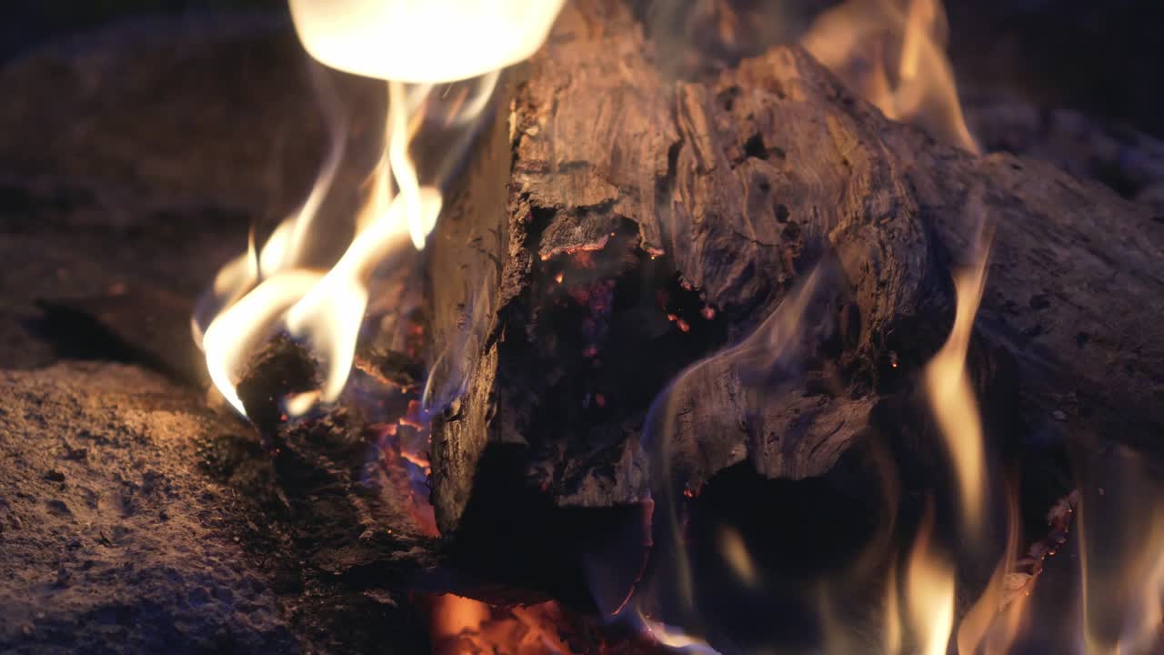 Cinematic campfire shot of burning wood chunk in a fireplace, the best quality