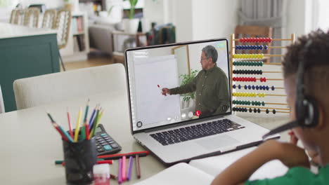 composición de un niño biracial en una computadora portátil aprendizaje en línea con un maestro masculino biracial
