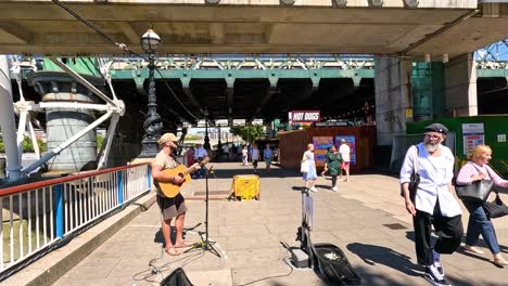 street musician playing guitar on bridge