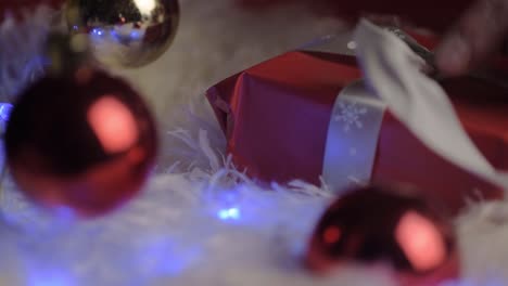 desenvolviendo un regalo de navidad envuelto con papel rojo y lazo con adorno rojo-1