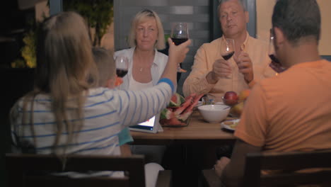 familia amistosa que tiene una cena al aire libre tardía