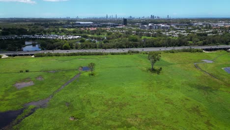 Aerial-over-Firth-Park-and-the-M1-looking-towards-the-Glades-and-Surfers-Paradise-Mudgeeraba,-Gold-Coast,-Queensland,-Australia