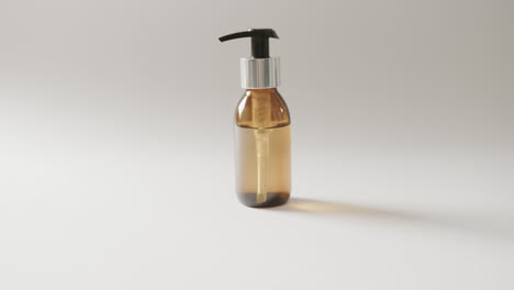 close up of glass bottle with pump with copy space on white background