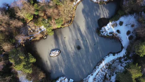 aerial drone birds eye view shot of frozen lake descending