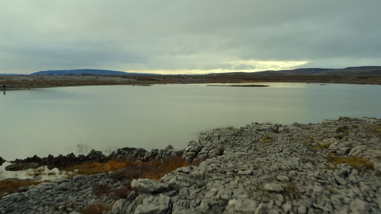 el dron se desliza bajo sobre el terreno de piedra caliza, cruzando el lago estacional de mullaghmore.