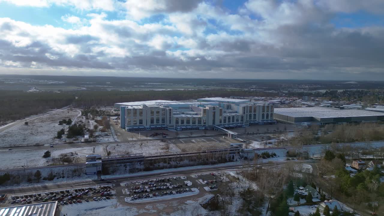 snowy train station with parked cars and surrounding buildings. Great aerial view flight wide orbit overview drone