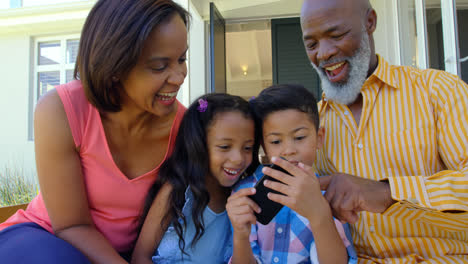 Front-view-of-black-family-using-mobile-phone-in-a-comfortable-home-4k