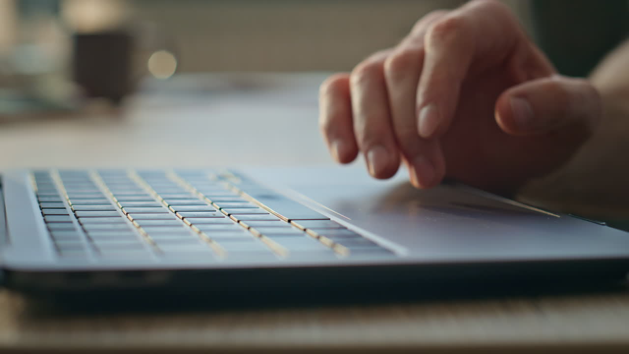 Programmer hands using touchpad working on laptop at remote office close up.