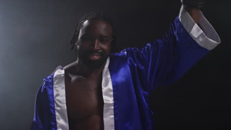 portrait of boxer entering ring before start of boxing match waving and greeting fans hitting gloves together with low key lighting 1