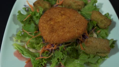 tots de brócoli y queso colocados sobre una ensalada de pollo