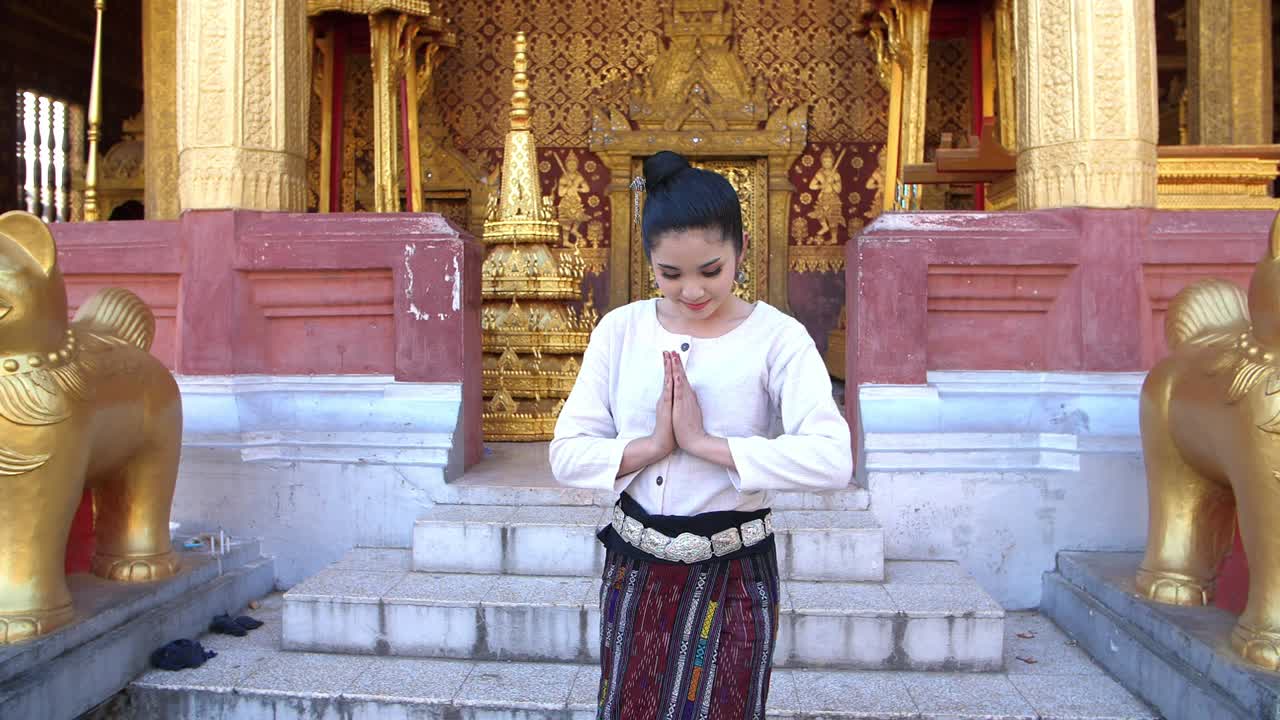 Woman in Traditional Thai Dress at a Temple