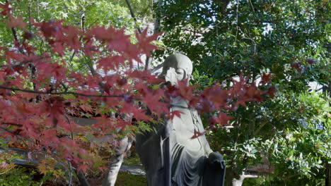 Buddha-statue-surrounded-by-Japanese-maple-leaves