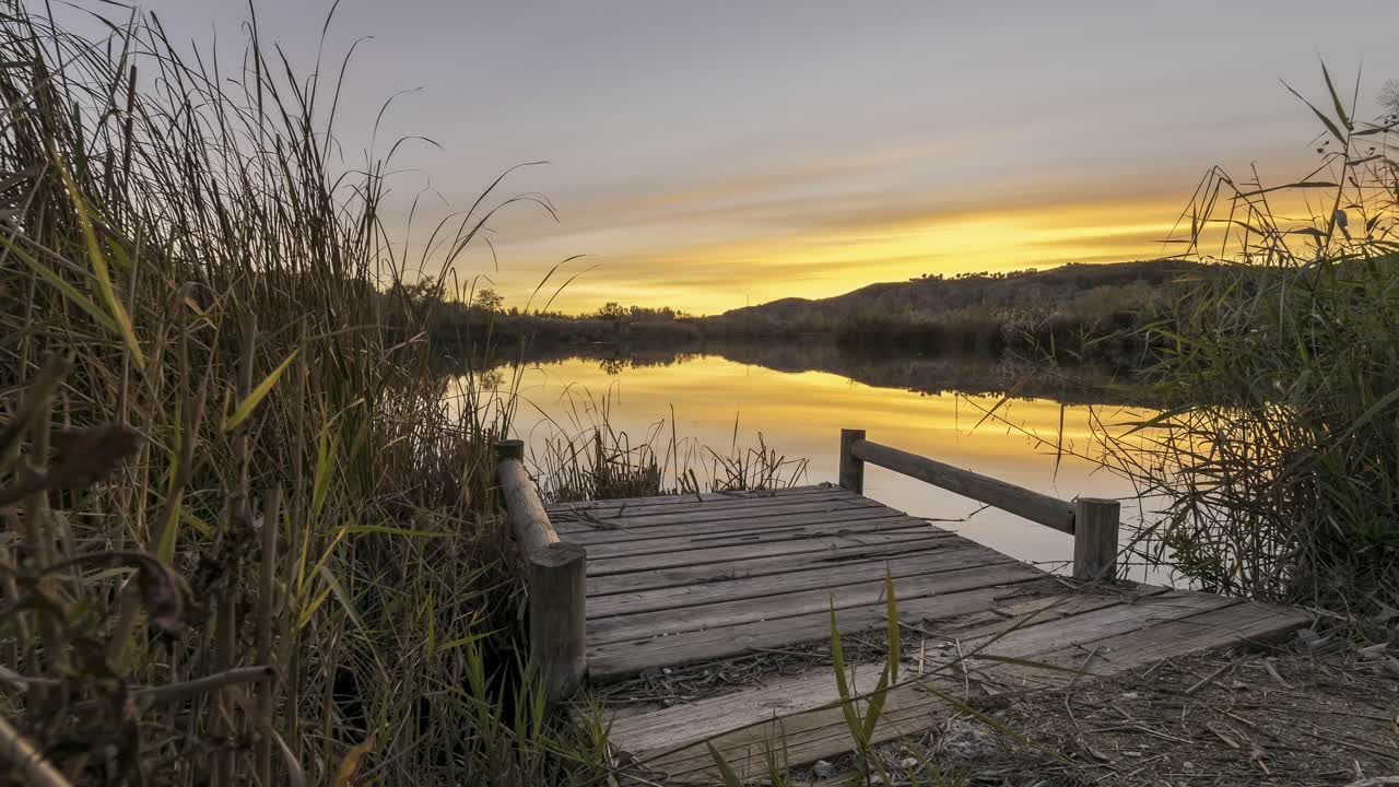muelle de madera en un lago tranquilo al atardecer
