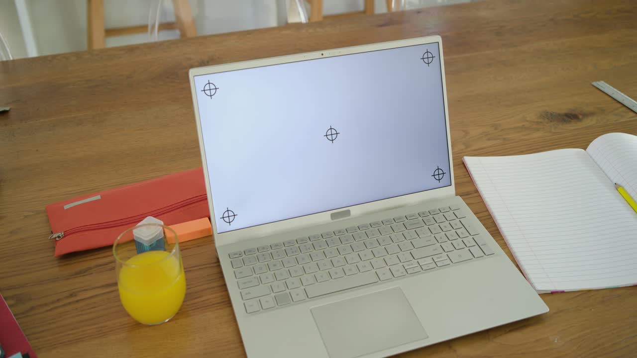 Operator is starting slow handheld pan toward white laptop on table, framing screen markers