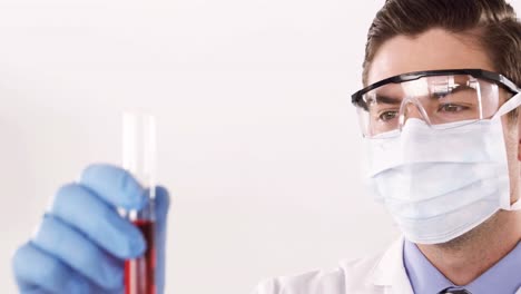 técnico de laboratorio chequeando una muestra de sangre en un tubo