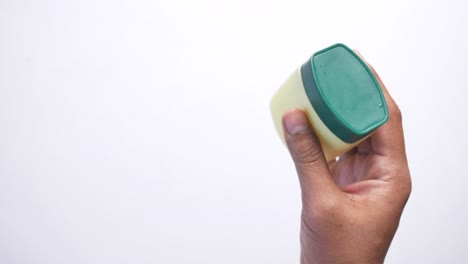 Top-view-of-man-hand-holding-a-petroleum-jelly-container-,