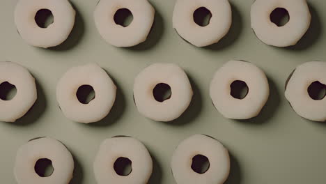 white glaze donuts on a light green background