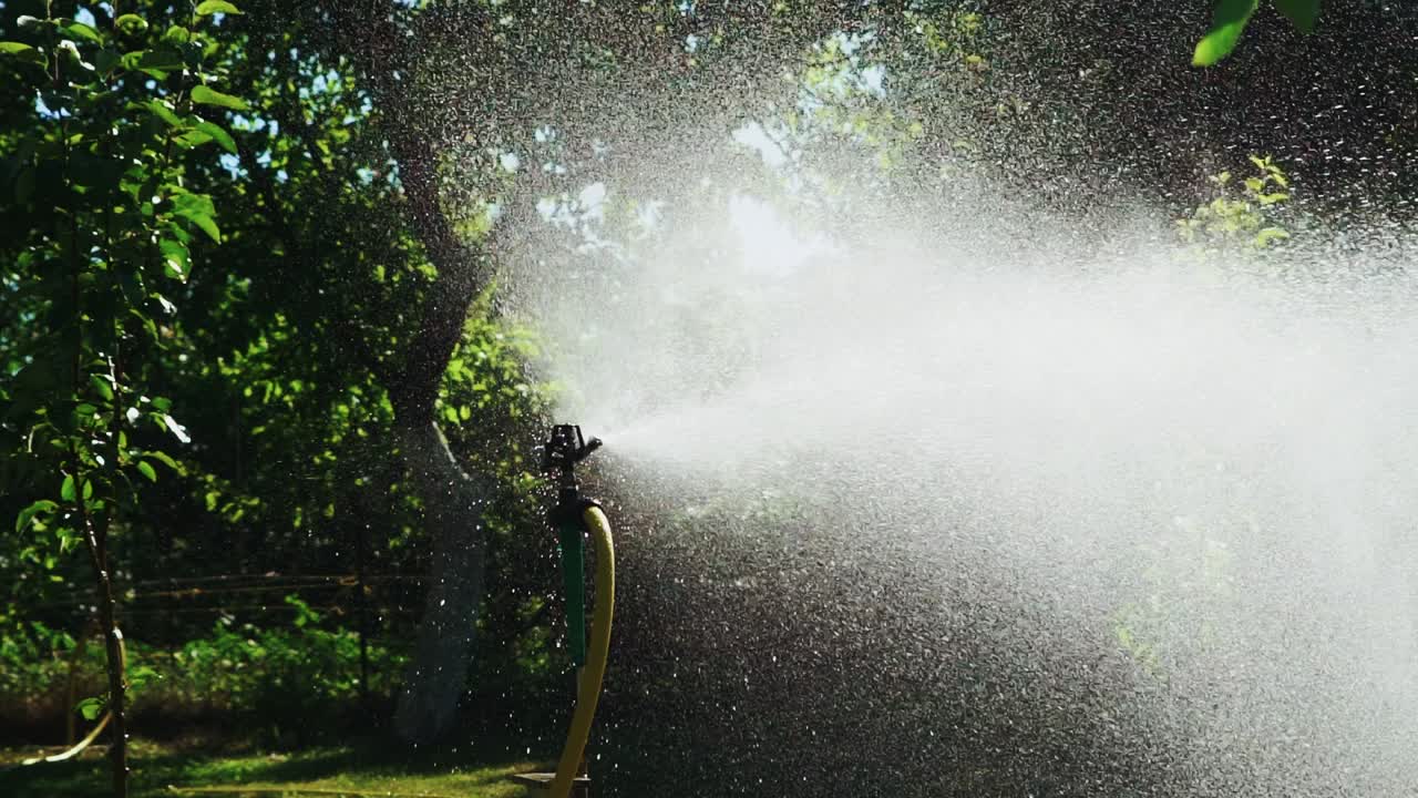 Irrigation equipment. Automatic agricultural sprinkler watering system for plants and lawn. Slow motion.