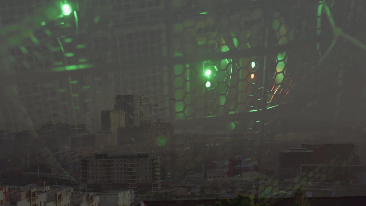 Honeycomb mesh grill overlaying urban cityscape, showing glowing green LED fans and cooling cables