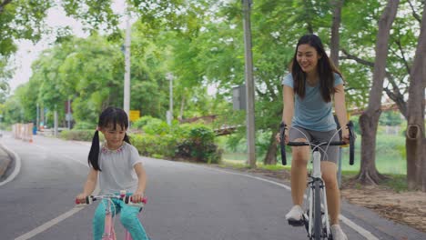 mother and daughter cycling in park