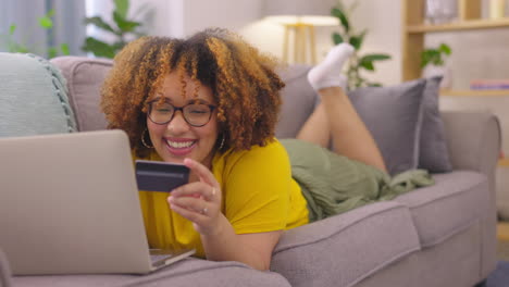 laptop, credit card and woman on a sofa