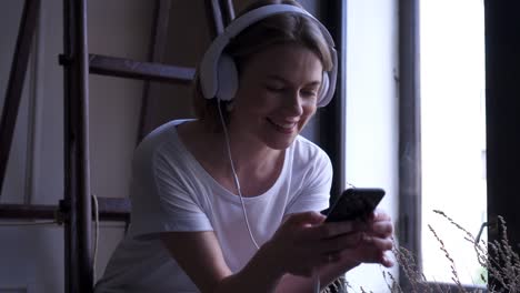 smiling girl in headphones texting on phone