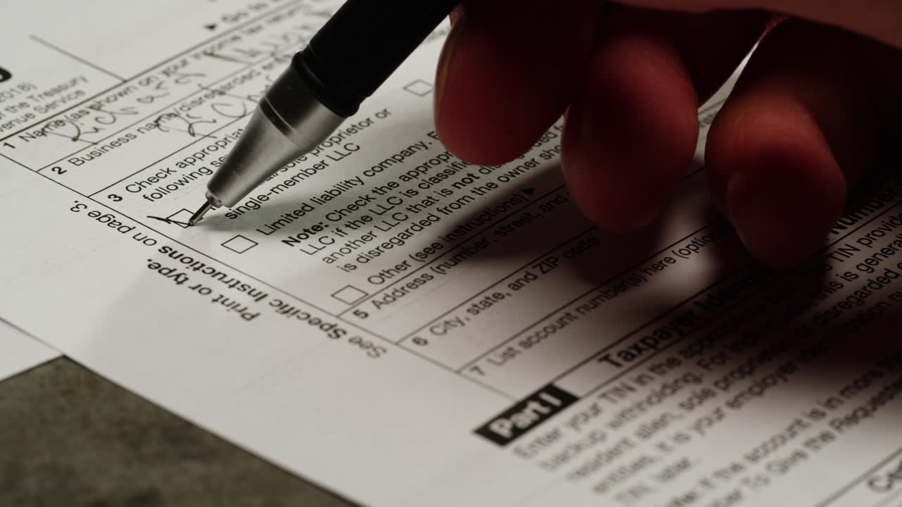 Close-up of Hand Checking Box on Tax Form W-9