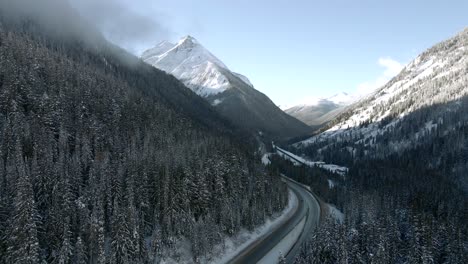 trans-canada highway 1 winter journey: vehicles travel across scenic landscape with majestic mountains in revelstoke, british columbia